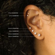 a woman's ear is shown with three diamond studs in the middle and four smaller diamonds on each side