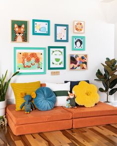 a living room filled with lots of pictures on the wall and furniture in front of it