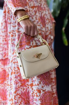 The Nina Handbag is the "go anywhere" bag that will elevate your style in an instant. It holds all the essentials and comes with a top handle and a crossbody gold chain strap. Nina is also compatible with any of our fashion straps (sold separately). Shown here with our Tortoise Resin Crossbody Chain Also shown with our navy/red scarf chain with the Red/Ivory stripe dress. Pebbled leather Top handle (drop is 4.5") Comes with an additional chain strap for crossbody carrying Flap closure with butte Luxury Spring Bags For On-the-go, Spring Pearl Handle Crossbody Bag, Everyday Handheld Bags With Gold-tone Hardware, Chic Satchel Bag With Pearl Handle, Gold Crossbody Shoulder Bag With Pearl Handle, Chic Gold Satchel With Top Carry Handle, Beige Top Handle Shoulder Bag With Pearl Handle, Trendy Cream Bag With Gold-tone Hardware, Trendy Cream Bags With Gold-tone Hardware