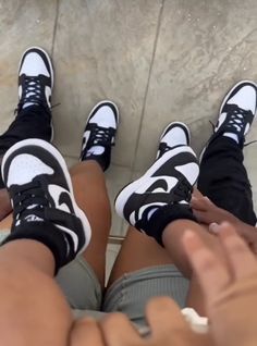 two people wearing black and white tennis shoes