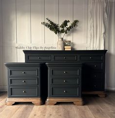 two black dressers with gold handles and drawers in front of a white paneled wall