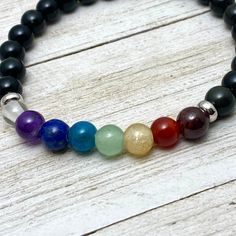 6 mm chakra gemstone bracelet Inspires balance of your 7 Chakras All natural gemstone beads: Crown (Clear or white), Third Eye (Purple ), Throat (Blue), Heart (Green), Solar Plex (Yellow), Sacral (Red-Orange), Root (Black-Silver) actual gemstones could vary based on availability, variations in color or size is a natural occurrence. Made with natural Obsidian base beads and strong elastic for years of easy wear. Message any special requests and options upon checkout Accent beads are solid stainle Rainbow Gemstone Beads Bracelet, Rainbow Gemstone Beads Bracelets For Healing, Rainbow Gemstone Beads Bracelet For Healing, Rainbow Gemstone Beads Healing Bracelet, Rainbow Round Beads Gemstones For Gift, Rainbow Crystal Bracelet With Natural Stone Round Beads, Rainbow Crystal Bracelet With Natural Stones And Round Beads, Rainbow Crystal Bracelet With Natural Stones, Rainbow Bracelets With Round Natural Stones