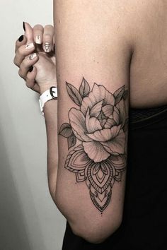 a woman with a flower tattoo on her arm