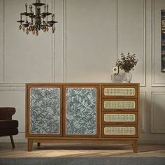 a living room scene with focus on the sideboard and chandelier in the background