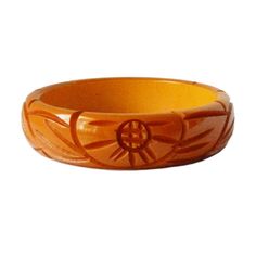 "Item: This is a lovely bakelite bangle bracelet carved with flowers and leaves on either side. It was made in the late 1930s and has a very deep yellow / orange color. It's in excellent condition, has been tested and guaranteed vintage bakelite. Be sure to check our other listings for lots more bakelite jewelry! Measurements: 3/4\" wide - 2 1/2\" inner diameter, 3\" outer diameter, 7 3/4\" inner circumference. Condition: 9.5 - Excellent Shipping: U.S shipping is $5.00 for USPS First Class Mail Vintage Bakelite Bangle Jewelry, Vintage Bakelite Bangle, Retro Bakelite Jewelry As Gift, Retro Bakelite Jewelry, Retro Round Bakelite Jewelry, Vintage Bakelite Bracelet, Vintage Carved Orange Jewelry, Orange Carved Vintage Jewelry, Vintage Orange Carved Jewelry