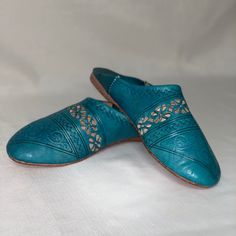 Women’s Leather Shoes 39 Hand Crafted Stamped Slip On Turquoise Blue Designed In Moroccan Aztec Boho Tribal Pattern. Delicate Embossed Patterns: The Finely Stamped Patterns Add A Touch Of Elegance And Authenticity To This Slipper, Making It One Of A Kind, Slip On Style With Flat Heel And Rounded Toe. Leather: Designed In Leather, This Shoe Slipper Combines Durability And Comfort To Provide You With An Exceptional Experience. Size Eu 39 - Translates To Us 9 Nwot - Mark At Heel Interior As Shown B Casual Blue Mules With Rubber Sole, Casual Blue Closed Toe Leather Shoes, Casual Blue Leather Shoes With Closed Toe, Casual Blue Leather Closed Toe Shoes, Casual Blue Mules With Cushioned Footbed, Blue Slip-on Leather Shoes For Spring, Blue Casual Leather Shoes With Round Toe, Blue Leather Shoes With Round Toe For Summer, Green Mules With Leather Footbed