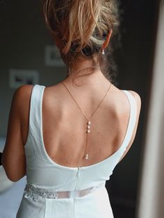 This body jewelry is designed to complement a wedding dress having a backless neckline. It is made with matte white porcelain beads, a silver or fine gold-plated steel chain, your choice. This back collar deliberately does not have an opening; it simply slips over the head, preferably before creating a hairstyle. This piece of jewelry is adorned on the front with white porcelain beads and Preciosa crystal settings. The back part is composed of three matte white porcelain beads and one hanging at Delicate Wedding Body Chain With Adjustable Chain, Elegant Wedding Body Chain With Adjustable Chain, Delicate Adjustable Wedding Body Chain, Delicate Adjustable Body Chain For Wedding, Delicate Wedding Body Jewelry With Delicate Chain, Elegant White Body Jewelry For Evening, Elegant White Pearl Chain Backdrop Necklace, Elegant White Backdrop Necklace With Pearl Chain, Elegant White Body Chain For Wedding