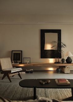 a living room filled with furniture and a painting on the wall above it's coffee table