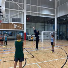 several children are playing basketball in an indoor gym