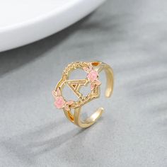 Material: Copper. Color: Gold, White Gold. Size: 5.0, 5.5, 6.0, 6.5, 7.0, 7.5, 8.0, 8.5, 9.0, 9.5, 10. Process: Gold plated. Recipient: Women, Mom, Wife, Girl Friend, Children, Family. Product Type: Personalized Jewelry. Gift Type: Ring. Occasions: Valentine's Day, Mother's Day, Christmas, Birthday, etc. Ring Type: Name Ring. Brand: Silviax Jewelry. Gold Flower Rings For Spring, Gold Floral Rings For Spring, Spring Flower-shaped Gold Rings, Spring Rose Gold Flower Ring, Spring Gold Jewelry, Letter Ring, Name Rings, Girl Friend, Pink Enamel