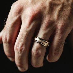 a man's hand with a gold ring on it