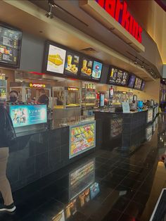 the inside of a fast food restaurant with menus on the walls and people walking by