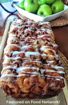 a loaf of cinnamon apple bread sitting on top of a table next to green apples