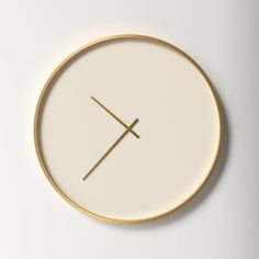 a white and gold clock with two crossed lines on it's face, against a white background