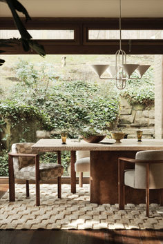 the dining room table is surrounded by two chairs and an area rug that looks like bricks