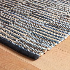 a blue and white rug on top of a wooden floor next to a wood floor