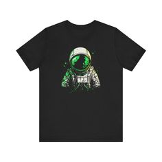 Step into the cosmos with our Galactic Explorer T-Shirt. This striking black tee features a vibrant astronaut graphic, highlighted by bold green accents and splashes of color that evoke a sense of adventure and exploration. Crafted from soft, breathable fabric, it offers both comfort and style, making it a perfect addition to any casual wardrobe.         Why You'll Love It: 👕 Ultimate Comfort: Made with 100% Airlume combed and ring-spun cotton, this tee offers a lightweight (4.2 oz/yd² or 142 g Astronaut Graphic, Meet Friends, The Cosmos, Green Accents, Just Relax, Casual Wardrobe, Leisure Wear, Fashion Lover, Semi Formal