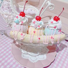 there are three desserts in the glass dish on the table with pink and white checkered tablecloth