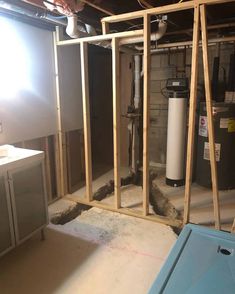 an unfinished room with pipes and water heater