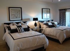 two beds with black and white comforters in a bedroom