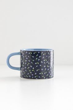 a blue and white coffee mug with small flowers on it