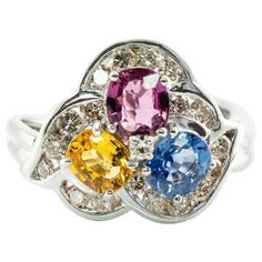 This gorgeous estate ring is finely crafted in solid 14K White Gold and set with genuine Earth mined Sapphires: blue, pink, and yellow gems. Each oval cut stone measures 5mm x 4mm totaling 1.35 carats. These amazing gems are so clean, clear, and transparent, with great intensity and strong brilliance. 18 surrounding diamonds are SI1 clarity and I color totaling .45 carat. Plus one .02 carat single cut diamond of VS1 clarity and G color in the middle. The top of the ring measures 13mm top to bott Multicolor Brilliant Cut Sapphire Ring For Formal Occasions, Multicolor Sapphire Multi-stone Ring, Multicolor Multi-stone Sapphire Ring, Multicolor Sapphire Ring In Fine Jewelry Style, Multicolor Sapphire Ring With Prong Setting For Formal Occasions, Elegant Multicolor Brilliant Cut Sapphire Ring, Formal Multicolor Sapphire Ring With Prong Setting, Multicolor Sapphire Ring With Brilliant Cut, Multicolor Oval Sapphire Ring For Anniversary