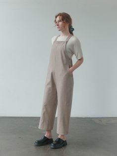 The Noemi Overalls feature a loose yet structured silhouette, perfect for layering all year round. These wide leg overalls have front and back pockets, with side seam button closure. The straps have an additional 1.5" length below the button in case of adjustments, but are already sized depending on length. These overalls are available in petite, standard, and long lengths. Model is wearing size SMALL standard length. Model is 5'7". Please review our size guide prior to ordering. Need specific m Workwear Overalls With Adjustable Straps, Everyday Bib Front Overalls With Pockets, Wide Leg Overalls For Fall Workwear, Workwear Overalls With Straight Leg And Side Pockets, Full Length Overalls With Pockets For Work, Relaxed Fit Bib Front Overalls For Workwear, Beige Workwear Overalls, Wide Leg Overalls, Square Neckline