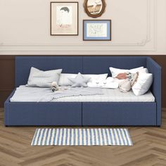 a blue daybed sitting on top of a hard wood floor next to a wall