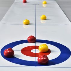 an ice hockey rink with red, yellow and blue balls