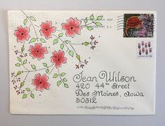 an envelope with flowers and leaves on the front is decorated with postage stamps, which are also used for wedding cards