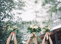 three bridesmaids holding up their bouquets in the snow