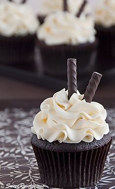 cupcakes with white frosting and chocolate sticks sticking out of them