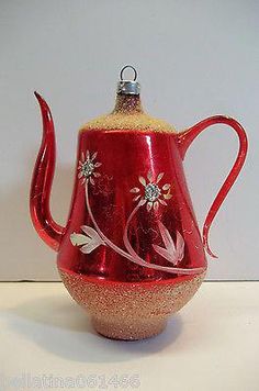 a red glass tea pot with flowers on it