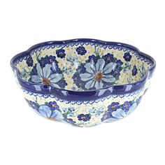 a blue and white bowl with flowers on the inside, sitting in front of a white background