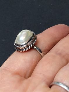 ► ABOUT THIS RING This is a vintage sterling silver statement ring with 1 off-white imitation Pearl. Wonderful craftsmanship. The front of the ring is 18x14mm. The ring band is 2.5mm wide. Our family acquired this ring around 1996, as part of a large jewelry collection. It's in great condition, unworn, antiqued and may be tarnished. It's been in storage all of these years. This ring would make a nice addition to any collection of beautiful heirloom jewelry. ► MORE FROM THIS SHOP See our other pe Classic White Cabochon Moonstone Ring, Handmade Vintage Oval Pearl Ring, Vintage Oval Sterling Silver Pearl Ring, Vintage Silver Oval Pearl Ring, Vintage Oval Pearl Ring In Sterling Silver, Handmade Vintage Pearl Ring In Sterling Silver, Handmade Vintage Sterling Silver Pearl Ring, Vintage White Handmade Rings, Handmade Vintage White Rings