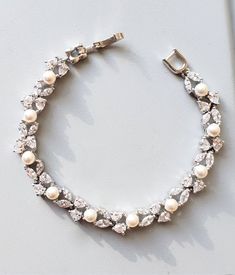 Swarovski white or cream round pearl with clear white cubic zirconia multi shape dainty bubble cluster rhodium bracelet. 8mm wide Matching earrings: https://www.etsy.com/shop/DesignByKara?ref=hdr_shop_menu&search_query=marquise+pearl+earrings Silver Cubic Zirconia Pearl Bracelet For Anniversary, Wedding Bridesmaid Jewelry, Bracelet Wedding, Jewelry Bridesmaid, Pearl Cluster, Wedding Jewelry Bracelets, Pearl Cream, Bridal Bracelet, Clear White