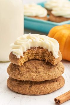 three cookies stacked on top of each other with white frosting and cinnamon sticks next to them