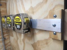 a close up of a parking meter attached to a wooden wall next to a metal pole