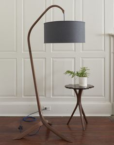 a lamp that is on top of a table next to a vase with a plant in it