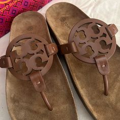 Leather Upper Rubber Sole Dual-Density Foam Insole Wrapped In Leather Designer Brown Sandals With Cushioned Footbed, Brown Almond Toe Sandals With Cushioned Footbed, Brown Suede Almond Toe Sandals, Tory Burch Slides, Blue Block Heels, Tory Burch Flip Flops, Tory Burch Ballet Flats, Blue Flip Flops, Rose Gold Sandals