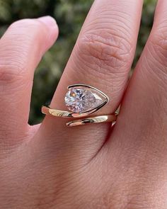 a woman's hand with a gold ring and a white diamond in the middle