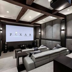 a home theater with two couches and a projector screen in the middle of the room