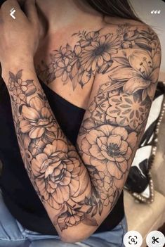 a woman's arm with flowers on it and her hand resting against her chest