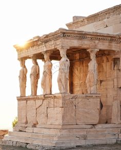 an ancient building with statues on the side and sun shining through it's windows