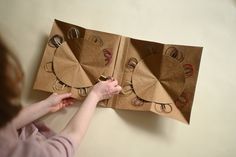 a woman is making an origami clock out of brown paper bags with scissors