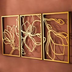 three metal artwork pieces hanging on the wall