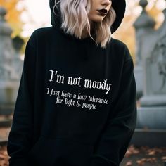 Gothic Hoodie with a funny Goth Quote on the front: I'm not moody, I just have a low tolerance for light & people. This black Spooky Hoodie creates a dark gothic and witchy style. Fun for a Halloween lover or a sarcastic person. ❗️❗️❗️Please be aware that the  Hoodie is an Unisex Cut and may be oversized.  Please check the size charts to measure yourself to be sure you will receive a good sized item. 🖤 The position, colors and size of the print may differ slightly from the illustrations. SHIPPI Winter Emo Sweatshirt With Letter Print, Alternative Style Halloween Hoodie With Letter Print, Alternative Halloween Hoodie With Letter Print, Emo Letter Print Sweatshirt For Fall, Hooded Hoodie With Letter Print For Alternative Fashion, Fall Hoodie With Letter Print For Alternative Fashion, Alternative Hoodie With Letter Print For Fall, Alternative Letter Print Hoodie For Fall, Witchy Clothes Aesthetic