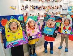 three young children holding up their art work