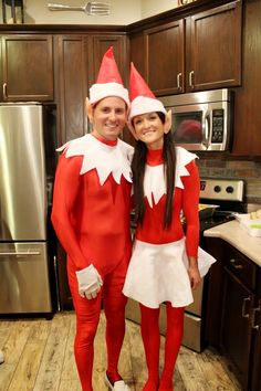 two people dressed up in elf costumes standing next to each other on a kitchen floor