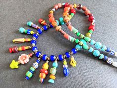 multicolored beaded bracelets are arranged on a gray surface